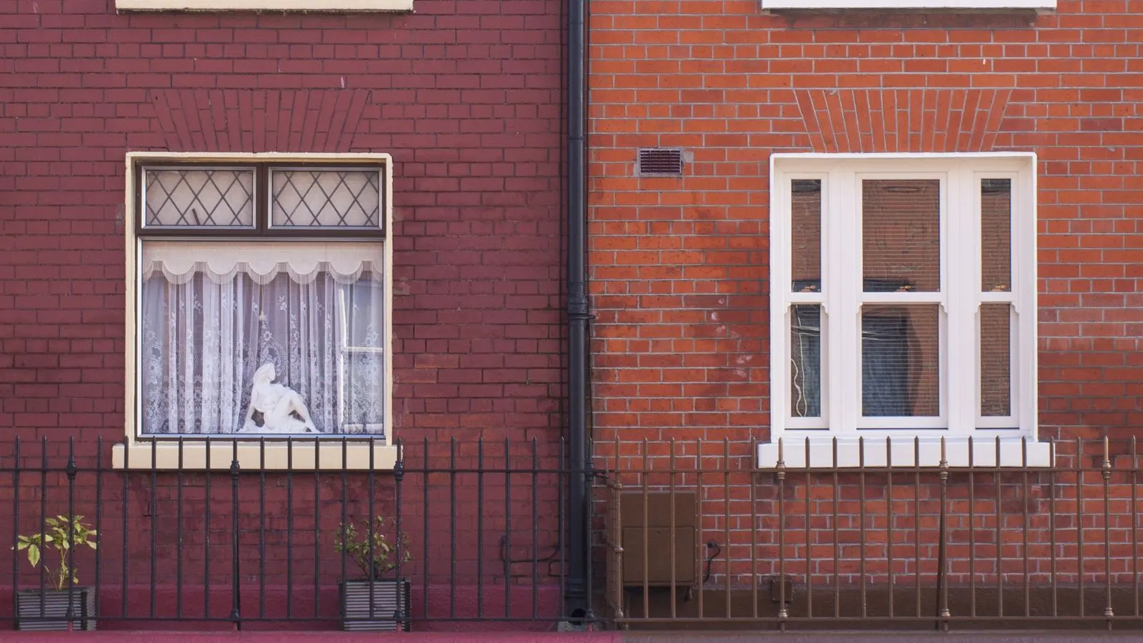 Two red-brick terraced houses with railings on a Dublin street