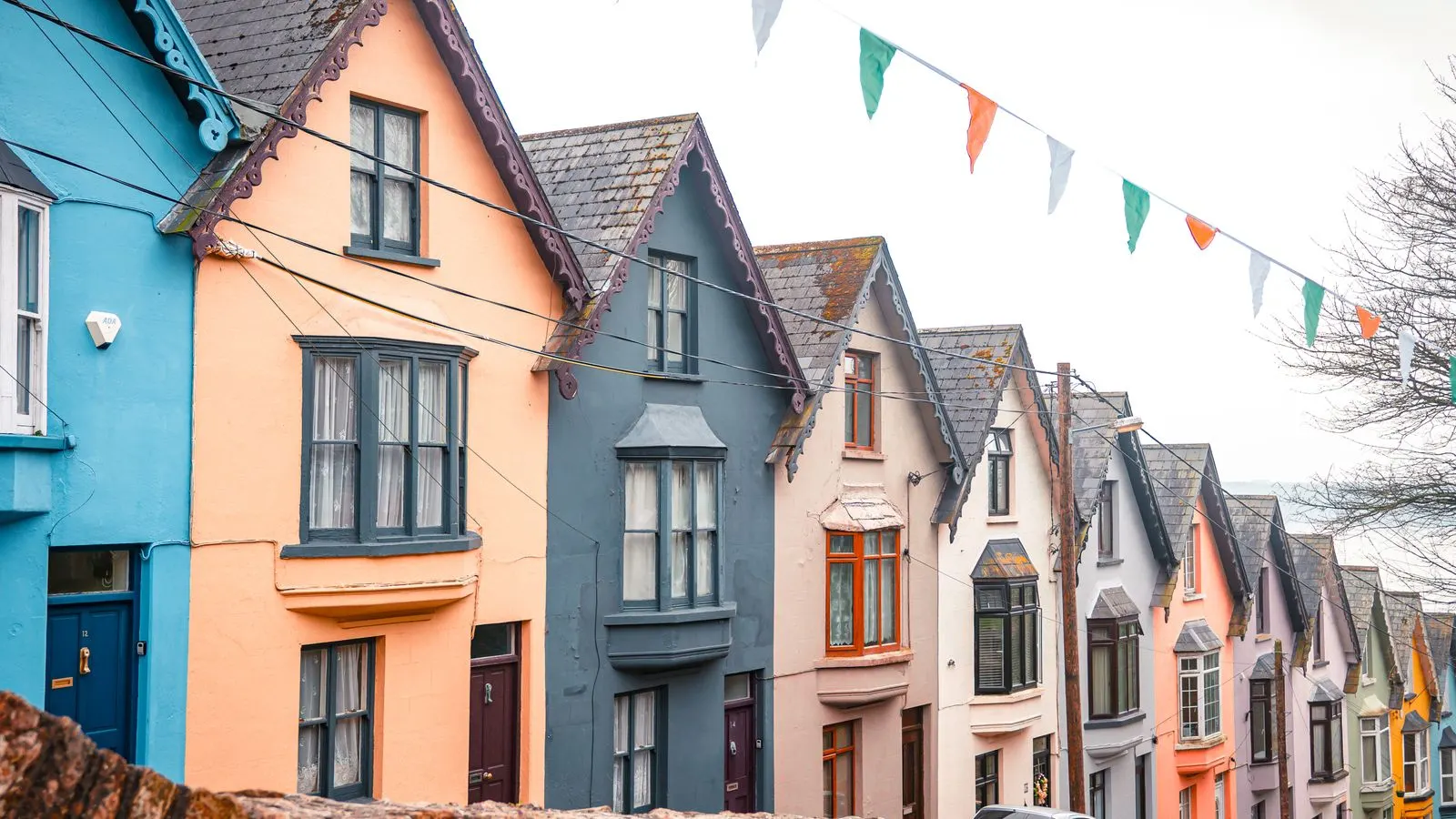 A row of brightly painted terraced houses on a steep street in Cobh, County Cork